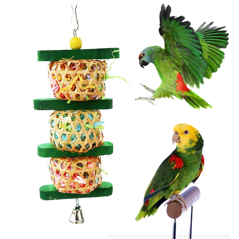 Hanging bird gnaw toy with woven paper cubes and green rings, shown with colorful parrots