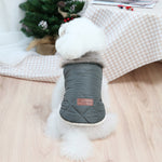 Quilted dog coat with dark gray outer shell and plush trim, front patch logo