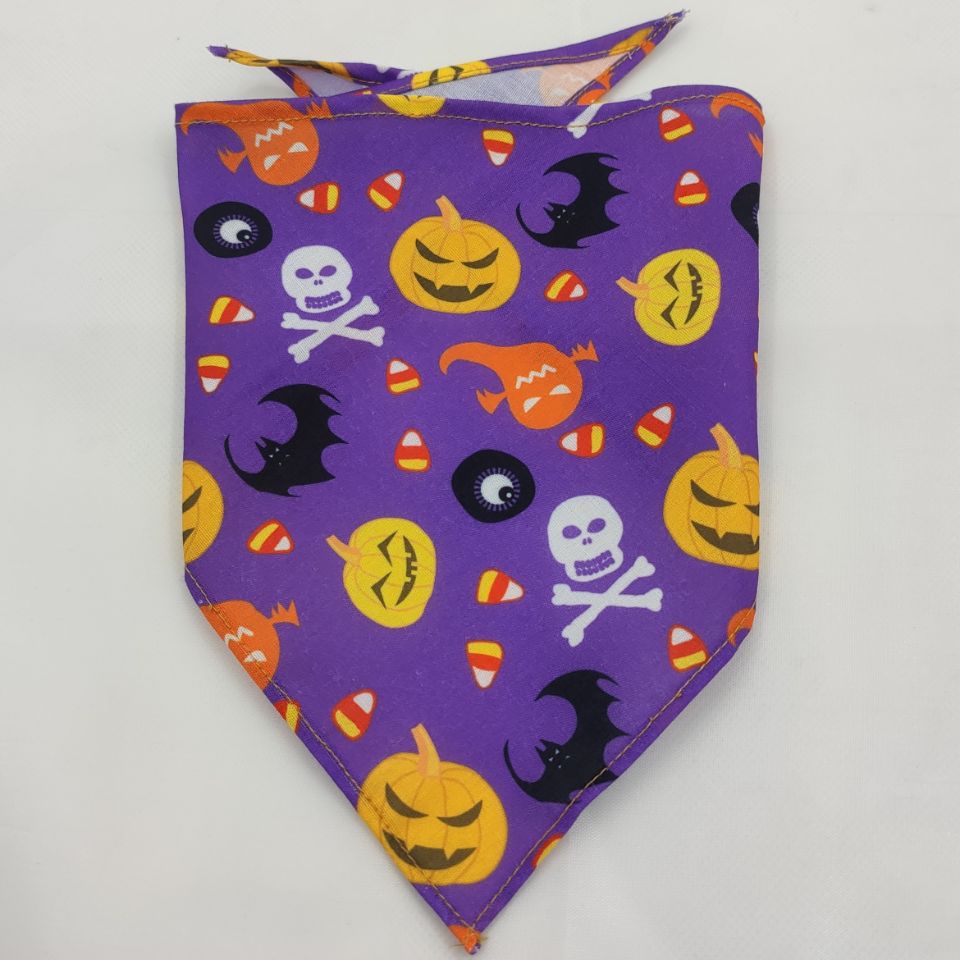 Pet triangle bandana in purple with black bats, skulls, and jack-o’-lantern faces