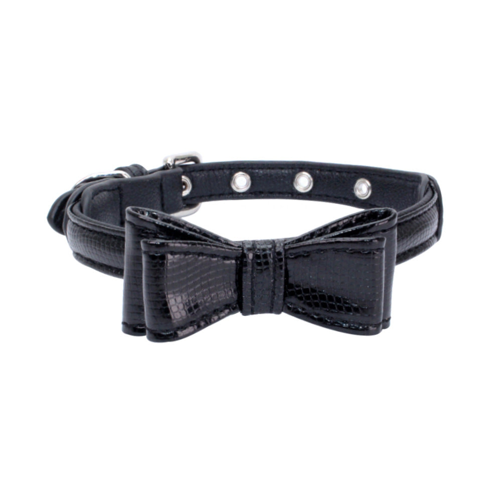 Pet collar with black textured strap and black bow detail, silver grommet studs