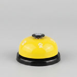Yellow paw press pet training bell with black base and paw-print button