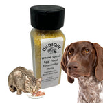 Quail egg food topper bottle with black cap beside dog and quail eggs in a bowl