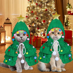Two cats in green Christmas tree hooded costumes with gold star, colorful pom-poms, and white ties