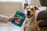 Pet treat bag with green Paw Snacks label, held near a tan dog