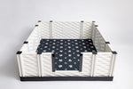 Black paw print pet mat fitted inside a white pet playpen base