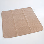 Tan square pet mat with quilted hex pattern and dark stitched border