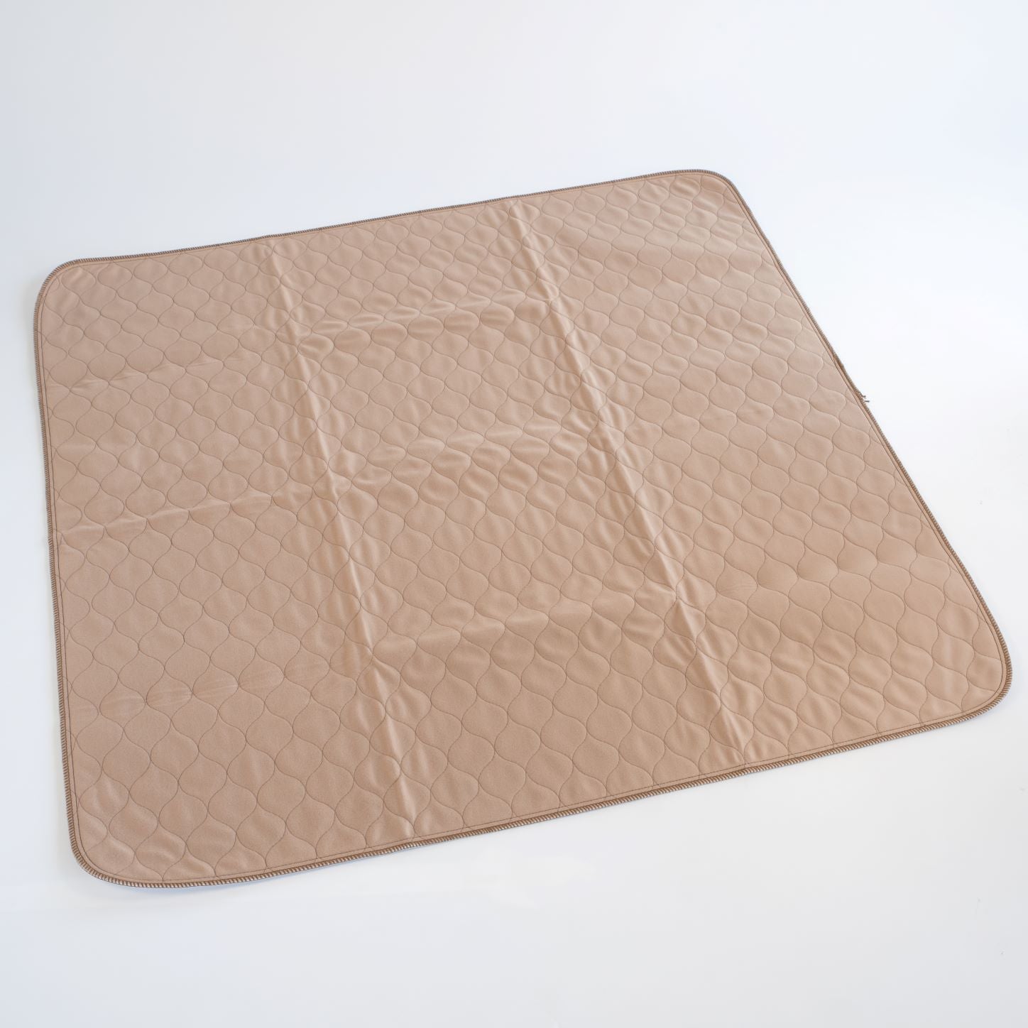 Tan square pet mat with quilted hex pattern and dark stitched border