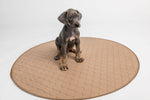 Tan round quilted pet mat with stitched perimeter edge