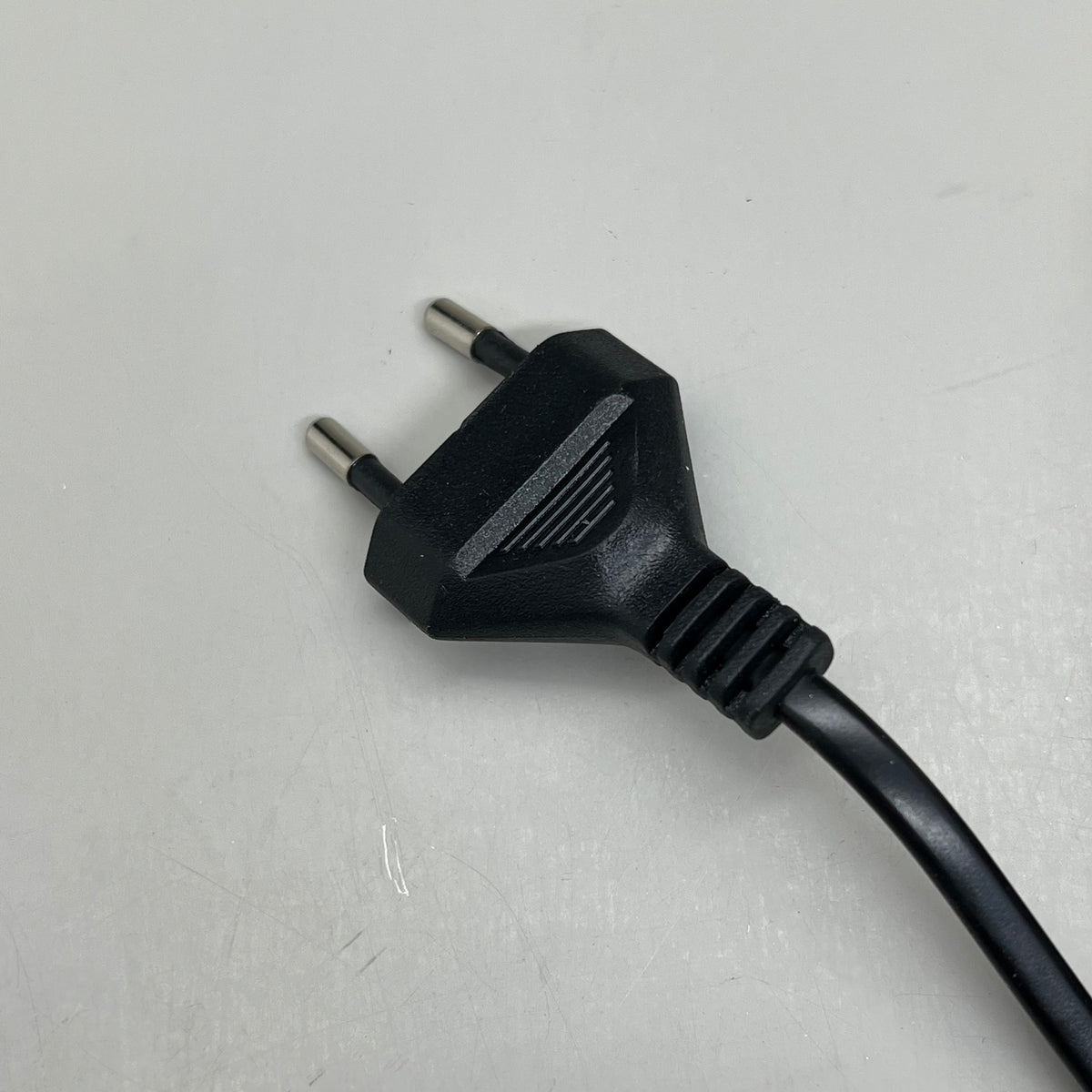 Two-prong power plug with attached black cord for wave aquarium pump