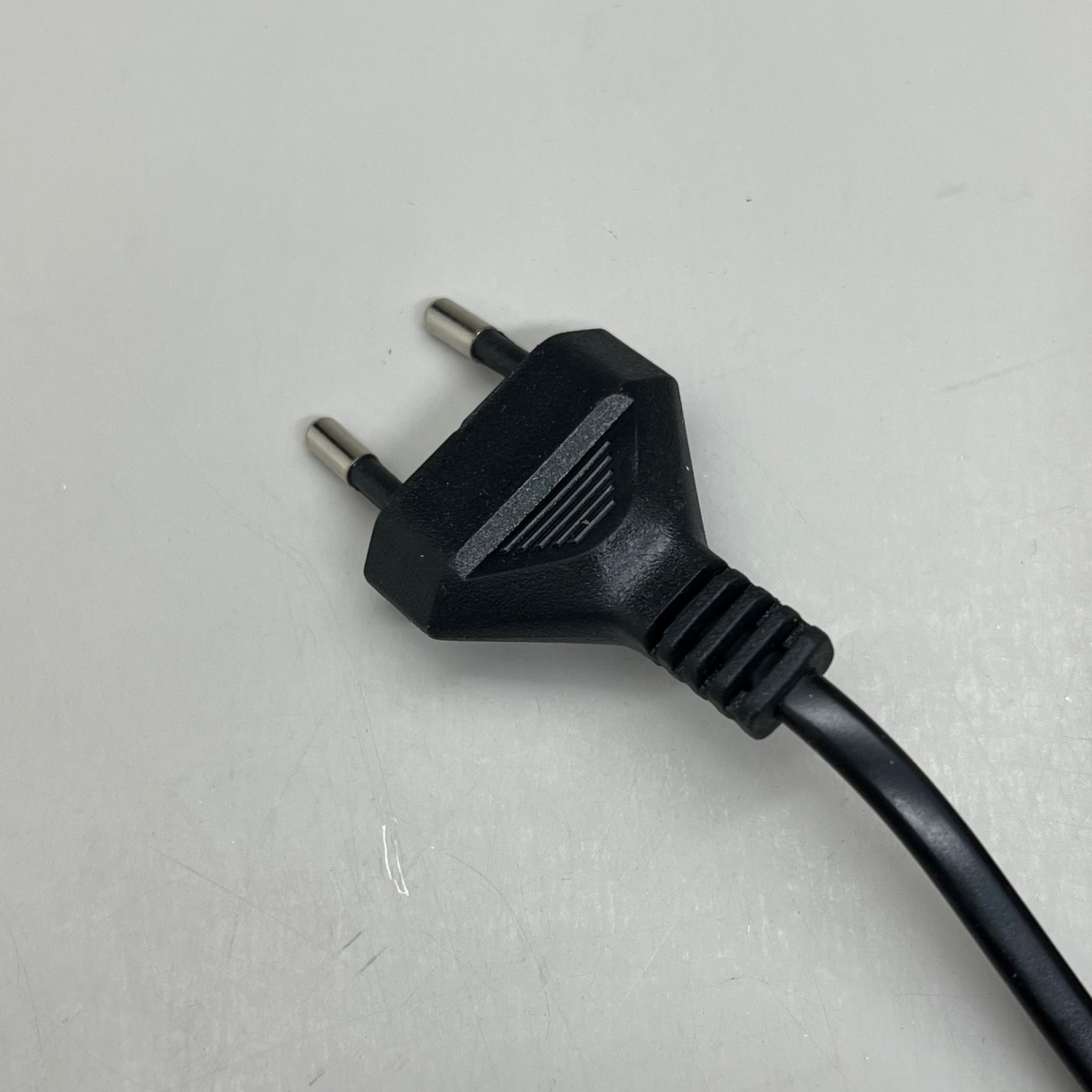 Two-prong power plug with attached black cord for wave aquarium pump