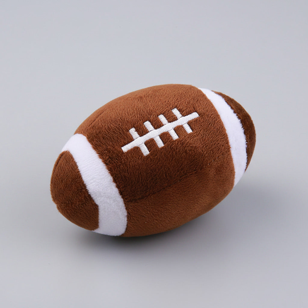 Plush squeaky dog ball toy shaped like a brown football with white laces