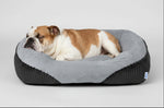 Grey faux fur pet sofa bed with dog resting in soft inner cushion and dark base