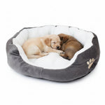 Gray round pet bed with white plush liner and paw emblem, two dogs sleeping inside