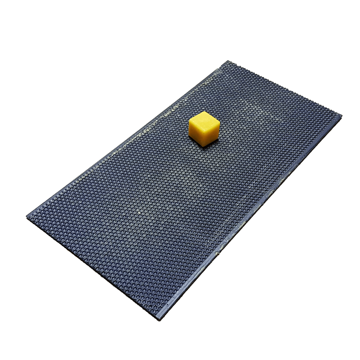 Dark plastic foundation sheet with small yellow wax block centered