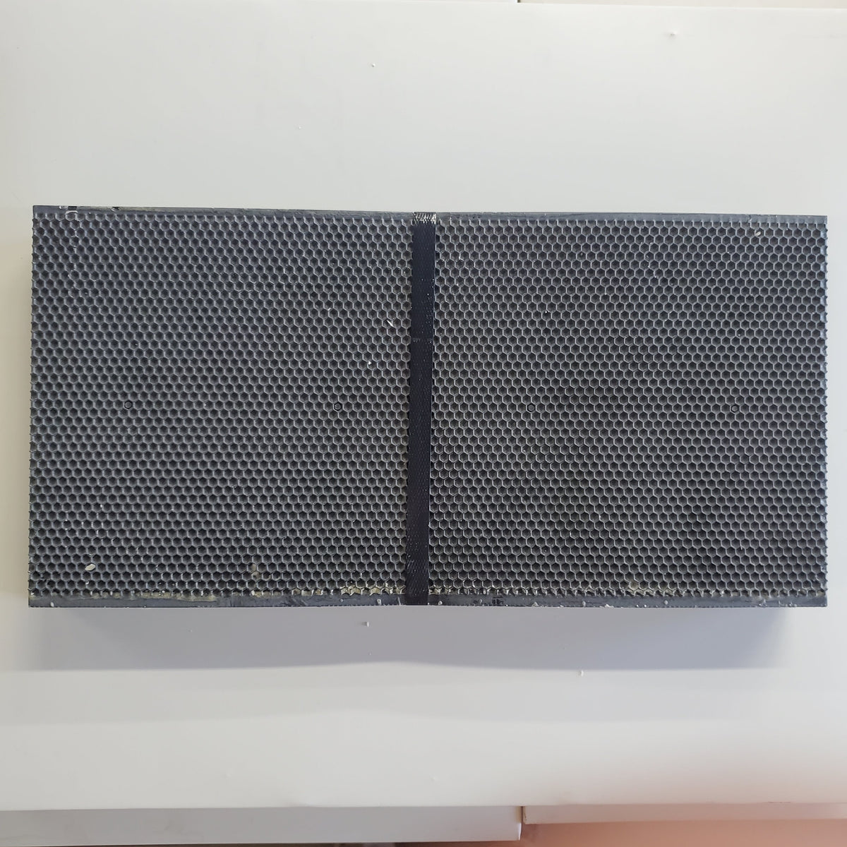 Two dark plastic foundation panels with dense hexagonal pattern