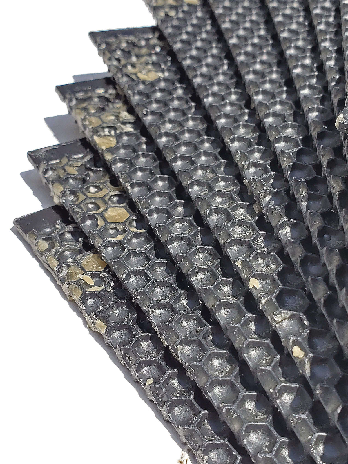 Stack of dark plastic foundation sheets with hexagonal cell pattern
