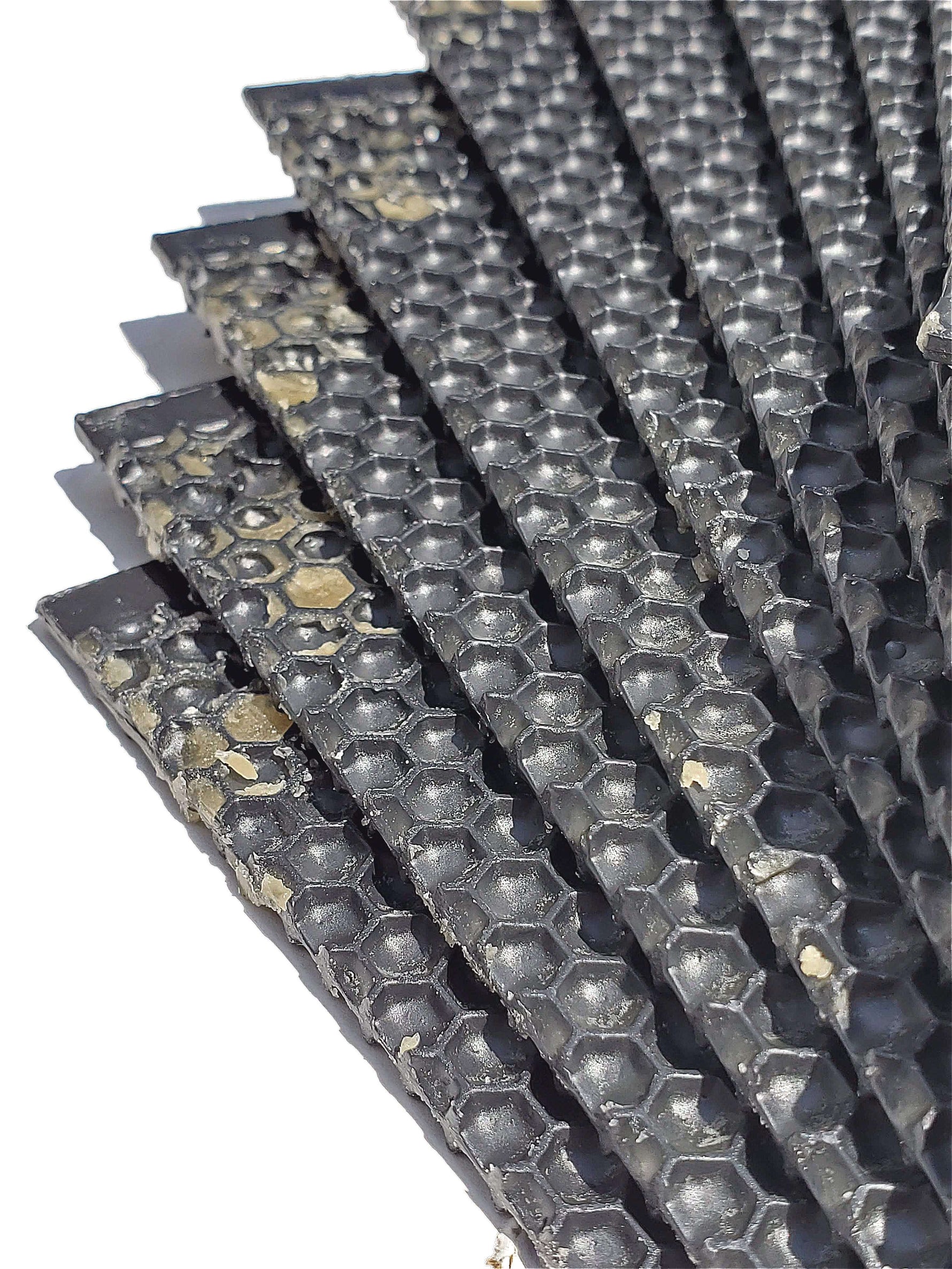 Stack of dark plastic foundation sheets with hexagonal cell pattern