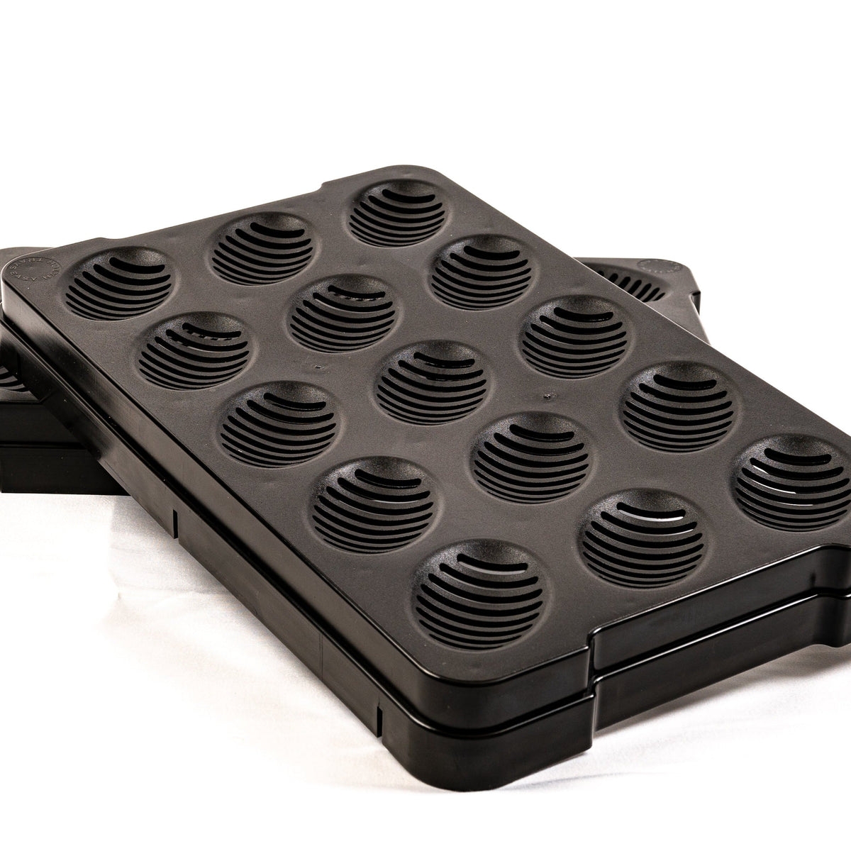 Black 15-slot hatch tray with ribbed circular egg wells, angled view