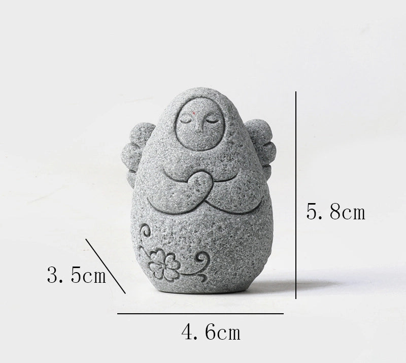 Speckled gray stone guardian ornament with hood, closed eyes, clasped hands