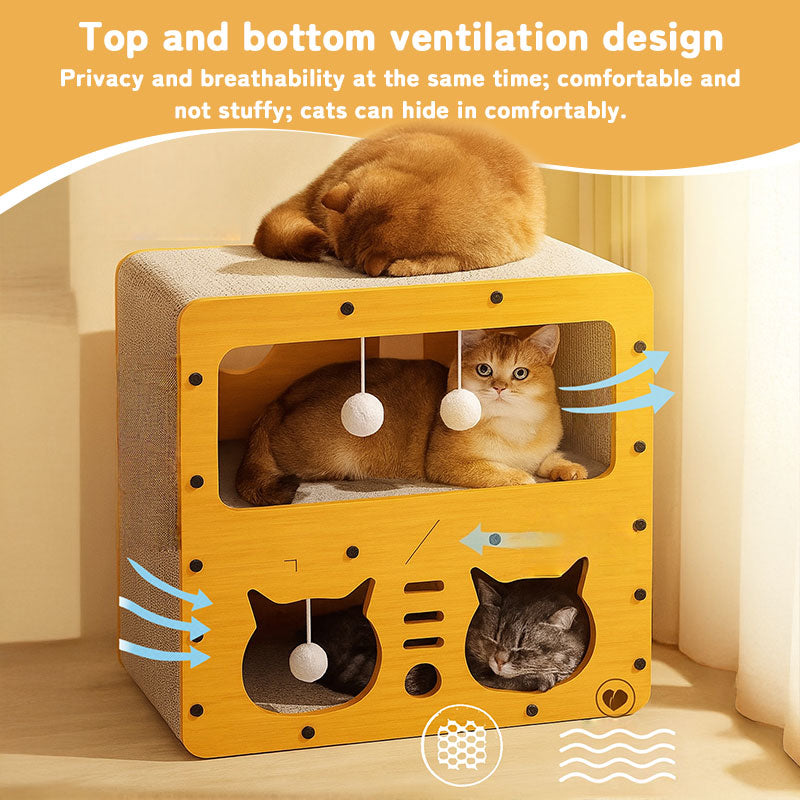Cardboard cat house with window panels and plush ball toys; orange cat napping inside