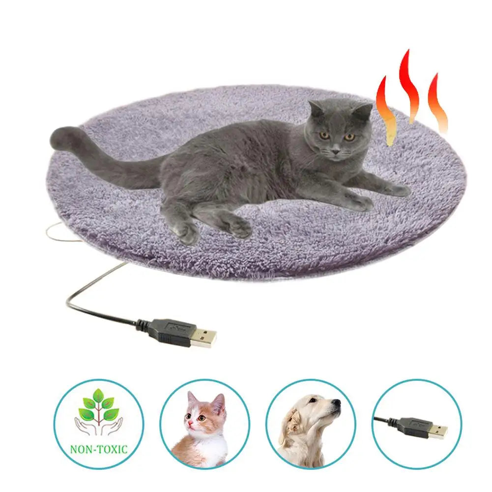 Electric heating pet bed mat, gray plush oval with USB cable, shown with cat on top