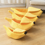 Yellow banana-shaped pet bed with plush bolster cushions and curved interior opening
