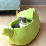 Banana pet bed in bright green crescent shape with padded sides, pet resting inside.