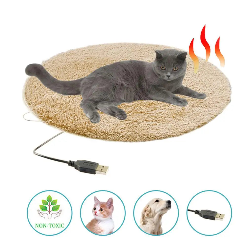 Electric heating pet bed mat, tan plush oval with USB cable, shown with cat on top