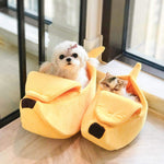 Banana pet bed in yellow with cushioned banana shape and black paw-print details, two pets.