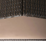 Pet bed interior corner showing dark wicker weave and beige cushion base