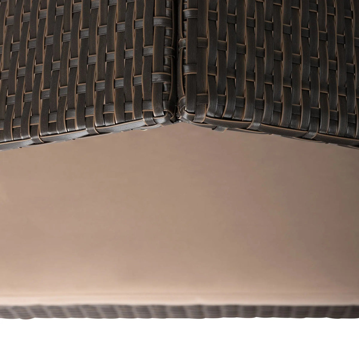 Pet bed interior corner showing dark wicker weave and beige cushion base
