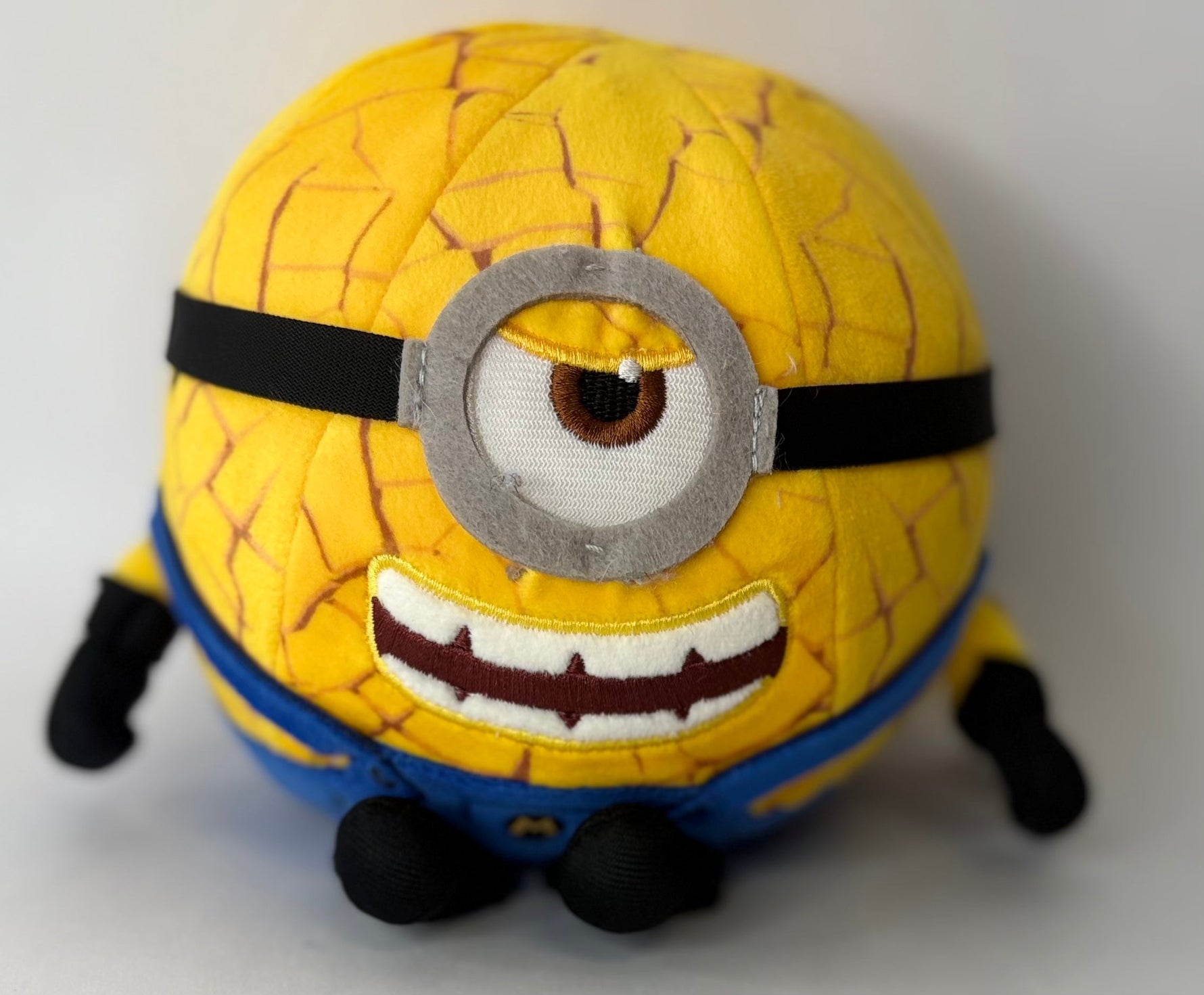 Yellow Minion plush with quilted texture and silver round goggles