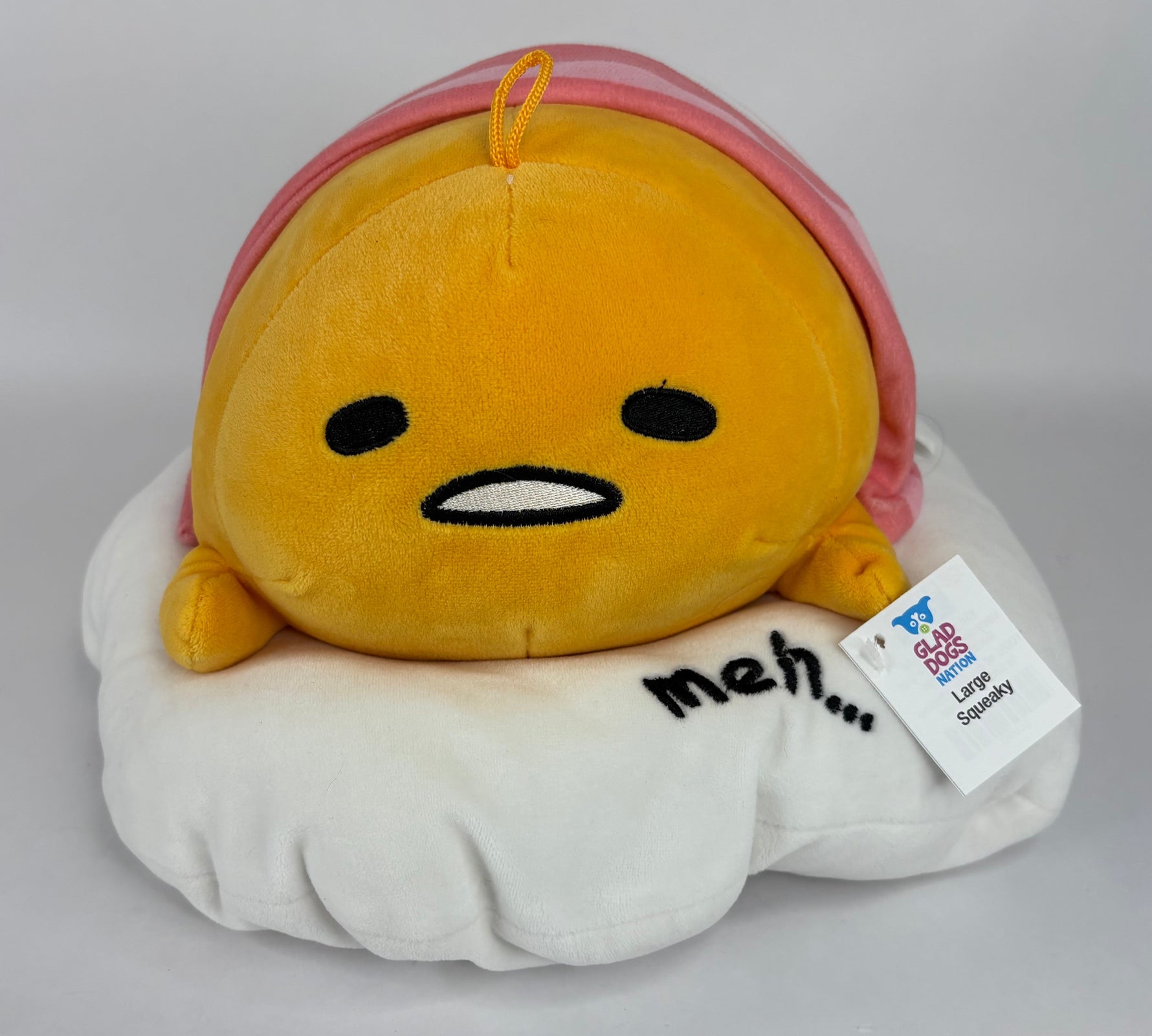 Large yellow and white plush character with hood, smile face, and “Mem.” patch