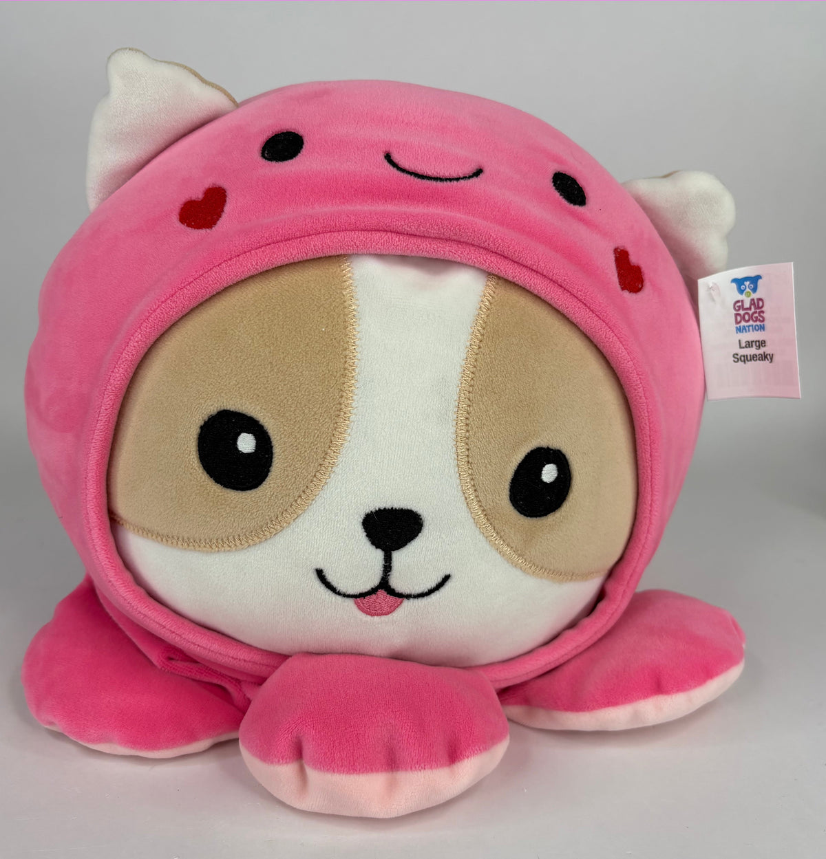 Large squishy plush pet toy, pink caped puppy face with tan ears and friendly eyes