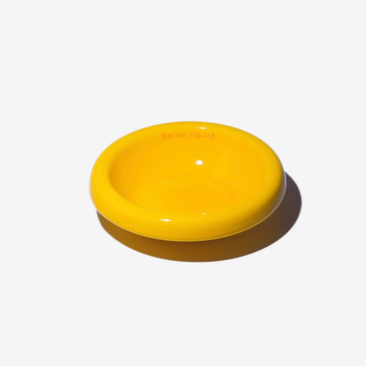 Stoneware pet bowl in bright yellow, round shallow dish with raised rim and glossy finish.
