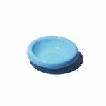 Stoneware pet bowl in light blue, round shallow dish with raised rim and glossy finish.