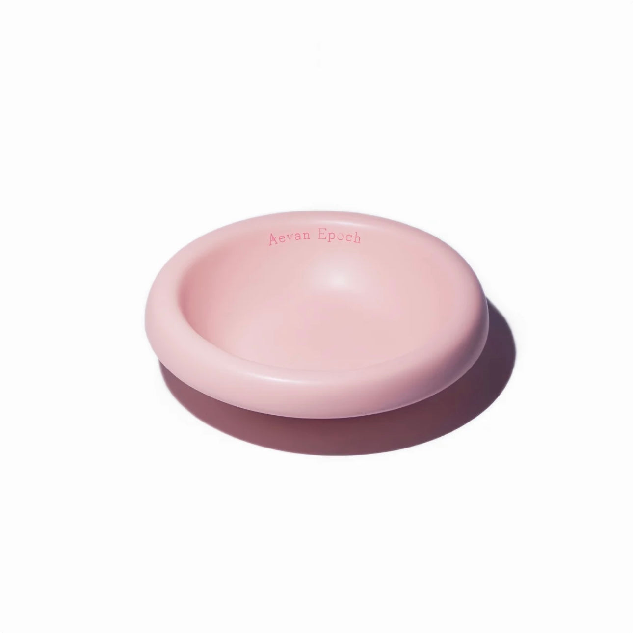 Stoneware pet bowl in pale pink, round shallow dish with raised rim and glossy finish.