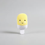 Yellow plush capsule-style dog toy with white legs and cute face
