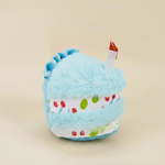 Light blue birthday cake plush dog toy with multicolor sprinkles and small red candle
