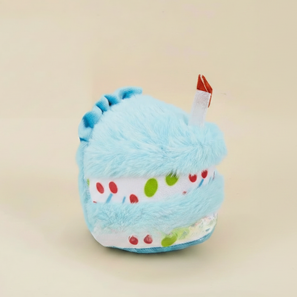 Light blue birthday cake plush dog toy with multicolor sprinkles and small red candle