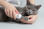 White precision pet clipper trimming a cat paw