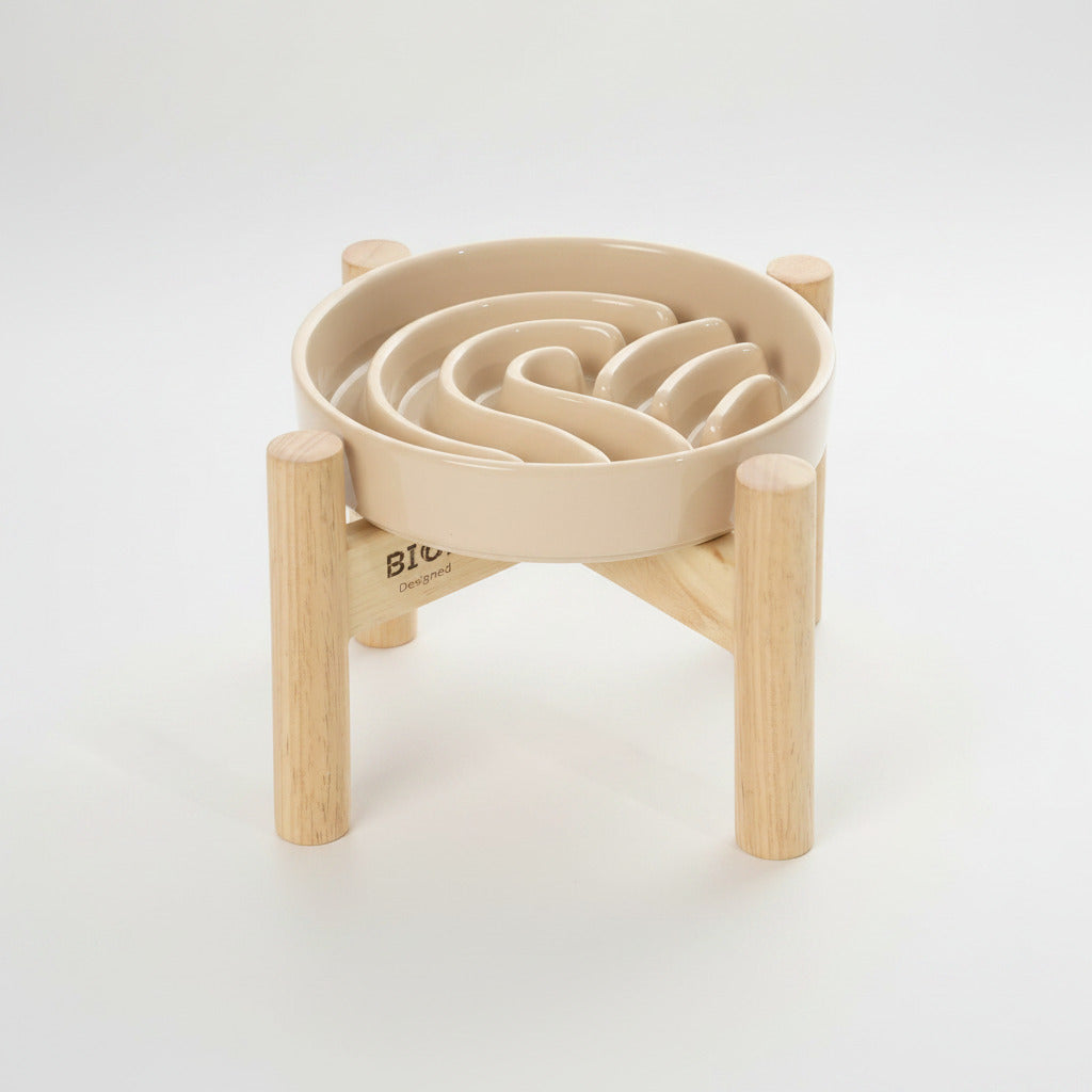 Beige wave slow feeder dog bowl on a wood stand with raised channels