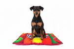 Colorful quilted pet bed with raised rim and red-orange-green graphic pattern