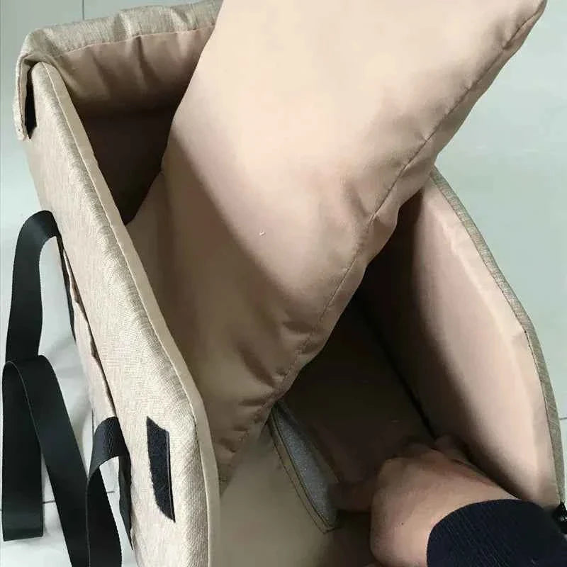Khaki pet seat bed with open interior, padded walls, and black carry straps