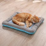 Light blue pet cooling mat with gray striped rim and quilted bubble surface