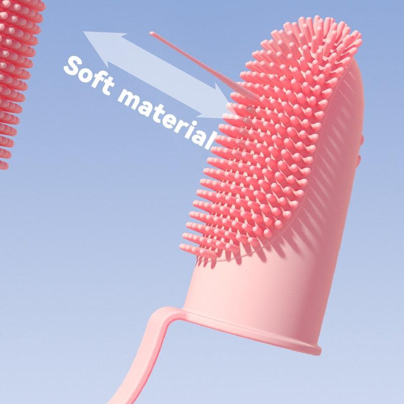 Pink silicone finger toothbrush with soft bristle nubs and flexible finger sleeve for pets.
