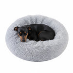 Plush round donut pet bed, light grey shag cushion with sleeping dog
