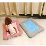 Two pet cooling mats: pink and light blue with gray-striped borders