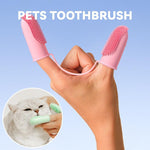 Pink silicone finger toothbrush tool with two bristle tips, hand-worn for pet oral care.