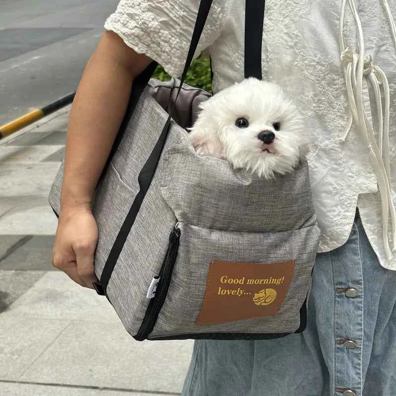 Gray pet carrier bag with shoulder straps, front zipper, and cushioned interior